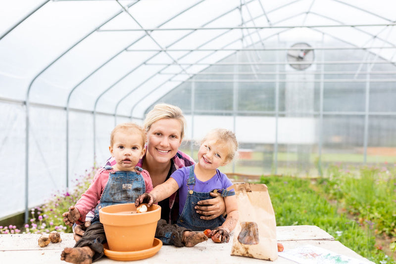 The Rooted Flowers family planting together in the greenhouse