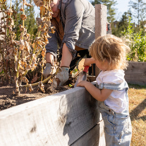 Person and child working together in a garden