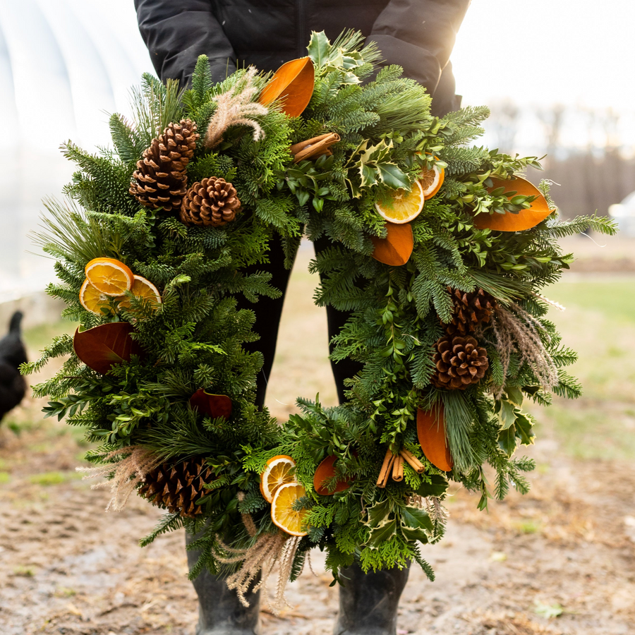 Hand-tied evergreen wreath with citrus, pine cones and mixed greenery at Rooted Flowers in Agawam, MA